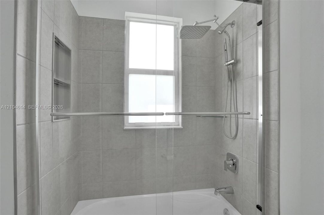 Bathtub with tile surround, built-in shower niche, and multi-function showerhead
