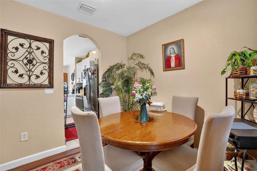 Dining space featuring an arched entryway and wood-finish flooring