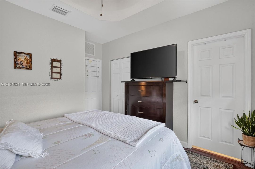 Tray ceiling, neutral wall tones, and multiple interior doors featuring traditional six-panel architectural detail