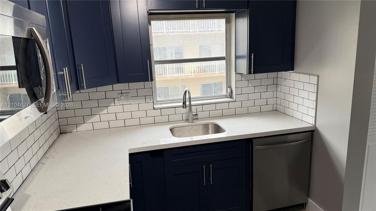 Quartz countertops with under mount stainless sink.