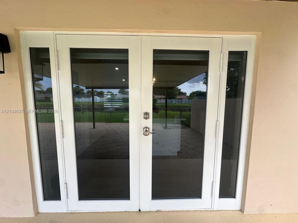 White-framed double French doors with transom windows