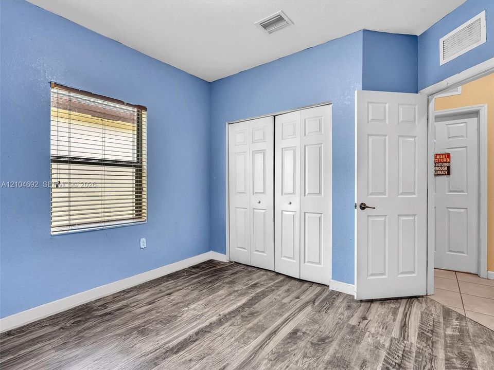 Room featuring wood-finish flooring, two-panel interior doors, and a double-door closet