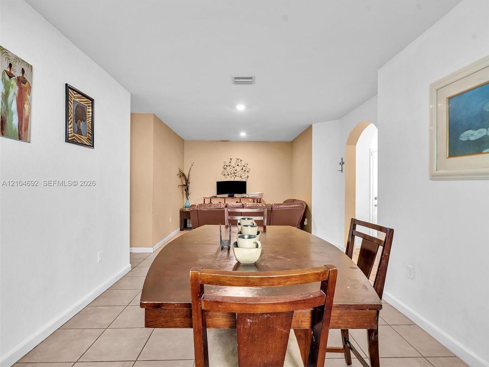 Neutral-toned interior featuring ceramic tile flooring, recessed lighting, and a decorative arched entryway