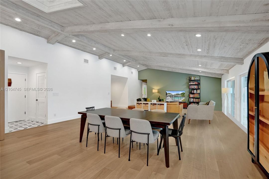 Vaulted wood-finish ceilings with recessed lighting, light wood-finish flooring, white walls, and a green accent wall