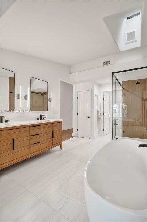 Dual vanity with wood-finish cabinetry, white countertop, and rectangular undermount sinks
