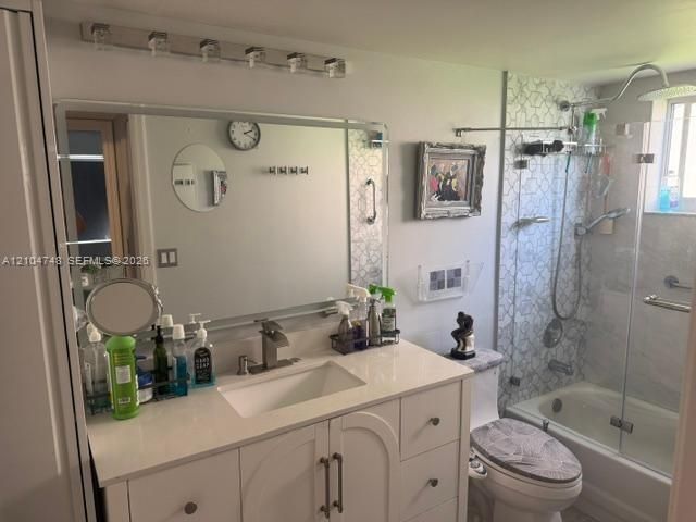 White vanity with a rectangular sink, quartz countertop, multi-light fixture, frameless glass shower enclosure, and intricate patterned tile wall surround