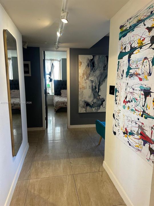 Tile flooring, track lighting, and a wall-mounted mirror