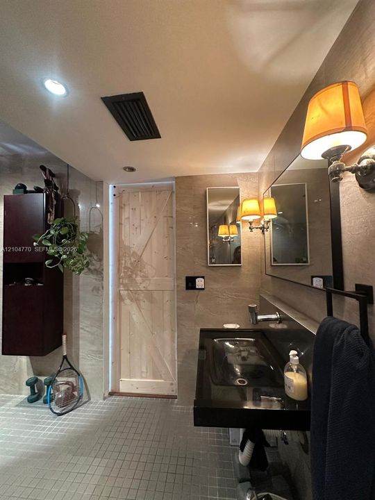 Floating black vanity with an integrated basin, wall-mounted faucet, and full-width mirror
