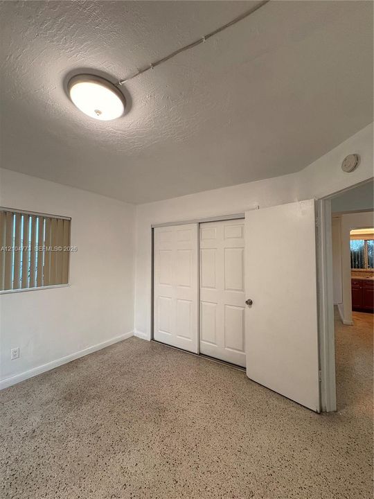 Recessed lighting fixture, sliding closet doors, window with blinds, wall-to-wall flooring