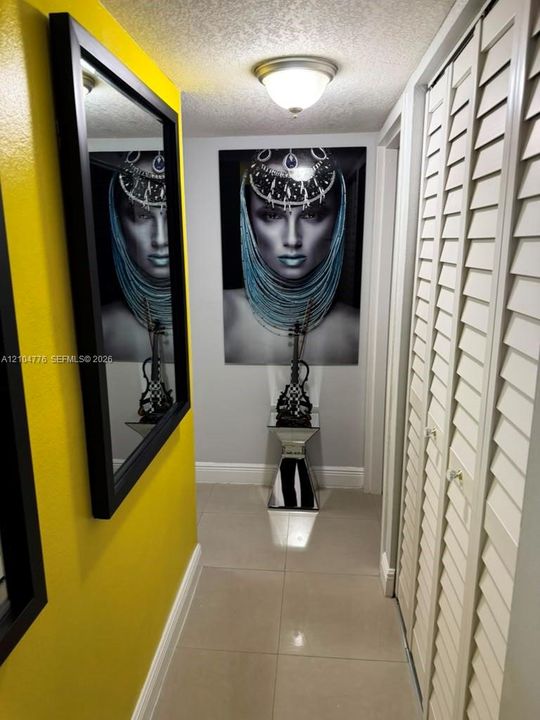Tile flooring, overhead lighting, louvered closet doors, and painted walls