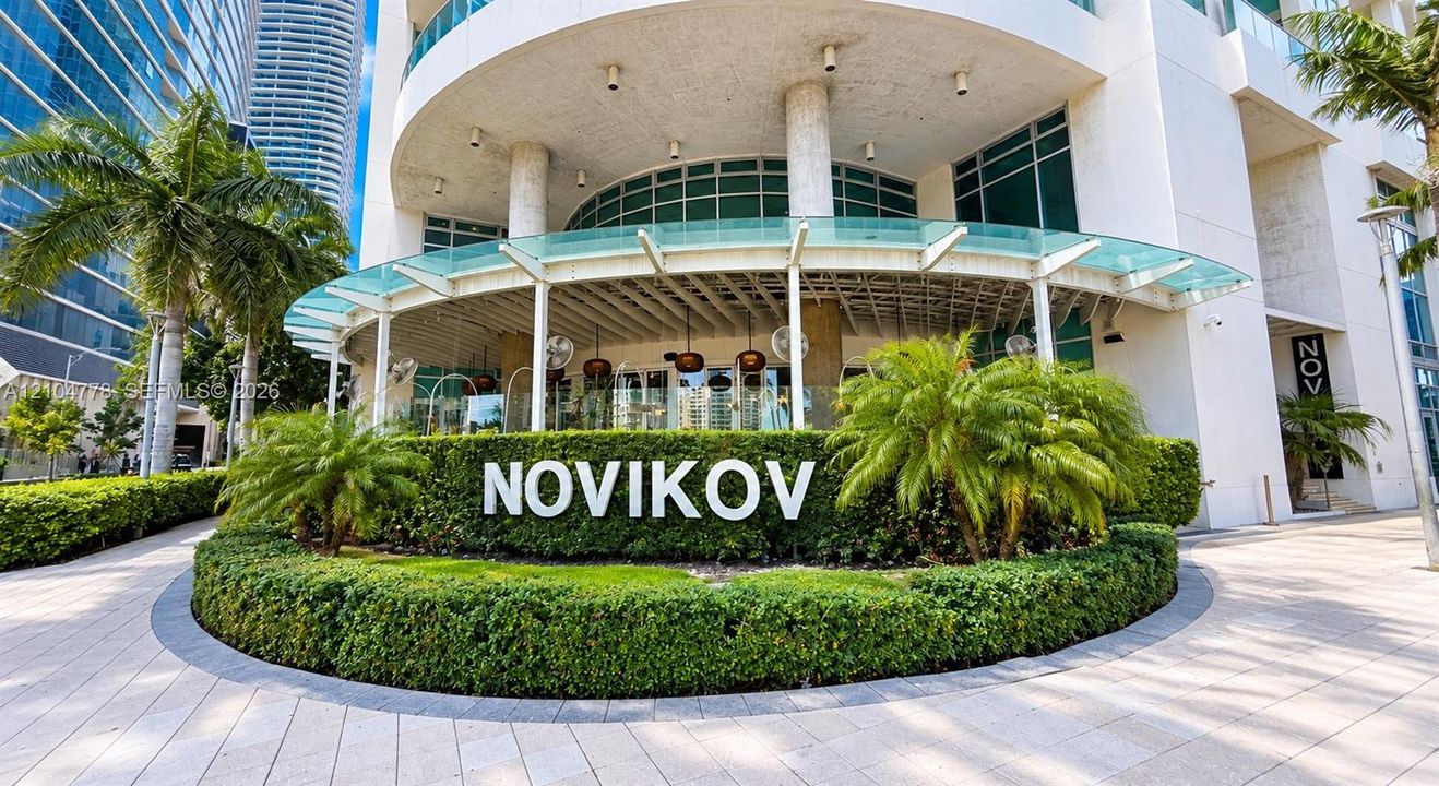 Curved architectural facade with a prominent entrance, glass awning, and integrated signage