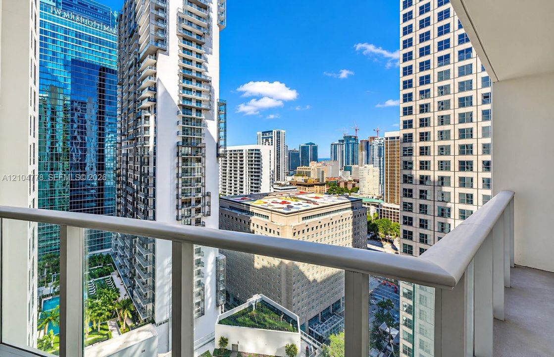 Balcony with glass panel railing and painted concrete flooring