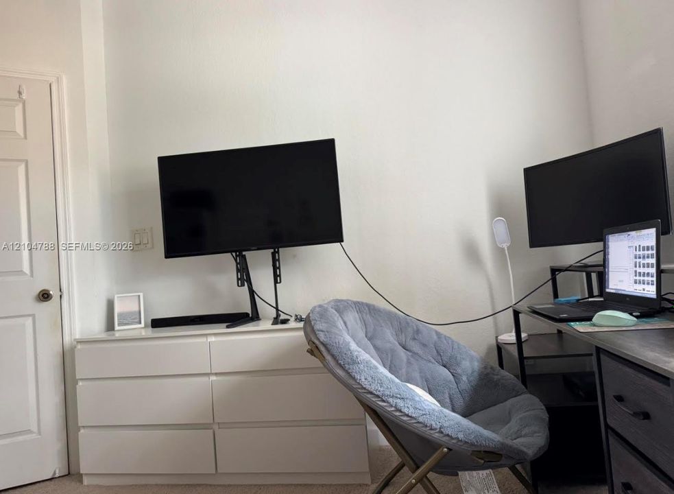 Interior room featuring a six-panel door with a metallic knob and neutral wall finish