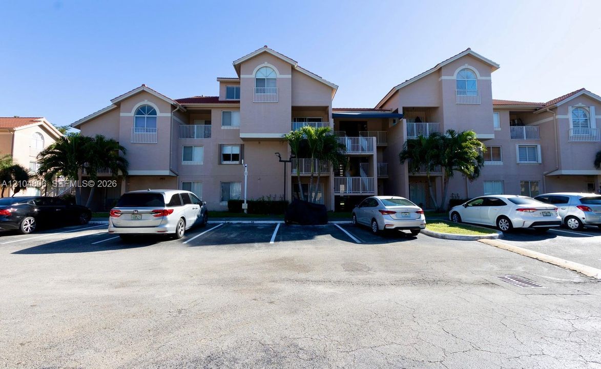 Multi-story building featuring balconies, arch-top windows, and a tile roof