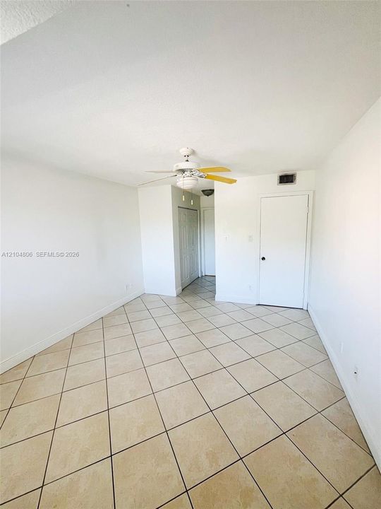 Tile flooring with a neutral finish, white walls, and a ceiling fan
