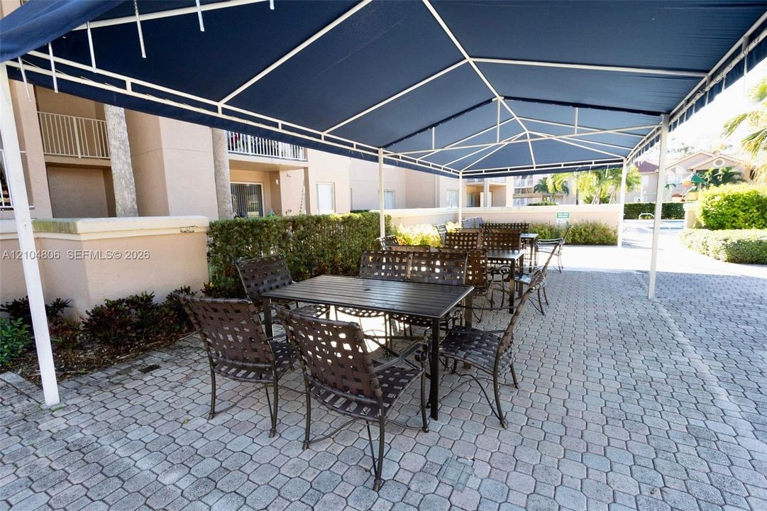 Paved patio area featuring a fixed overhead canopy