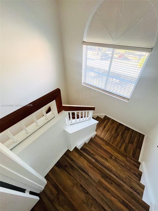 Wood-finish flooring on staircase with white risers