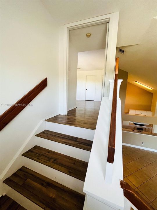 Staircase featuring wood-finish treads and white risers