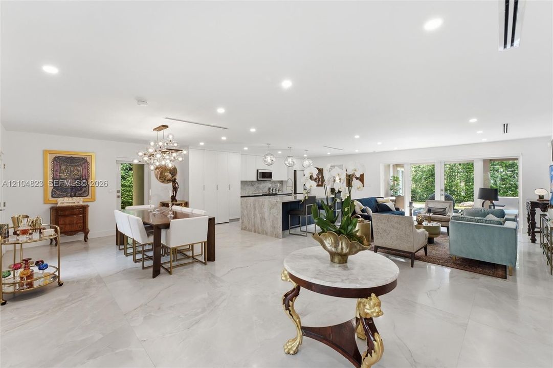 Expansive open-concept space with large format tile flooring, recessed lighting, and a contemporary chandelier