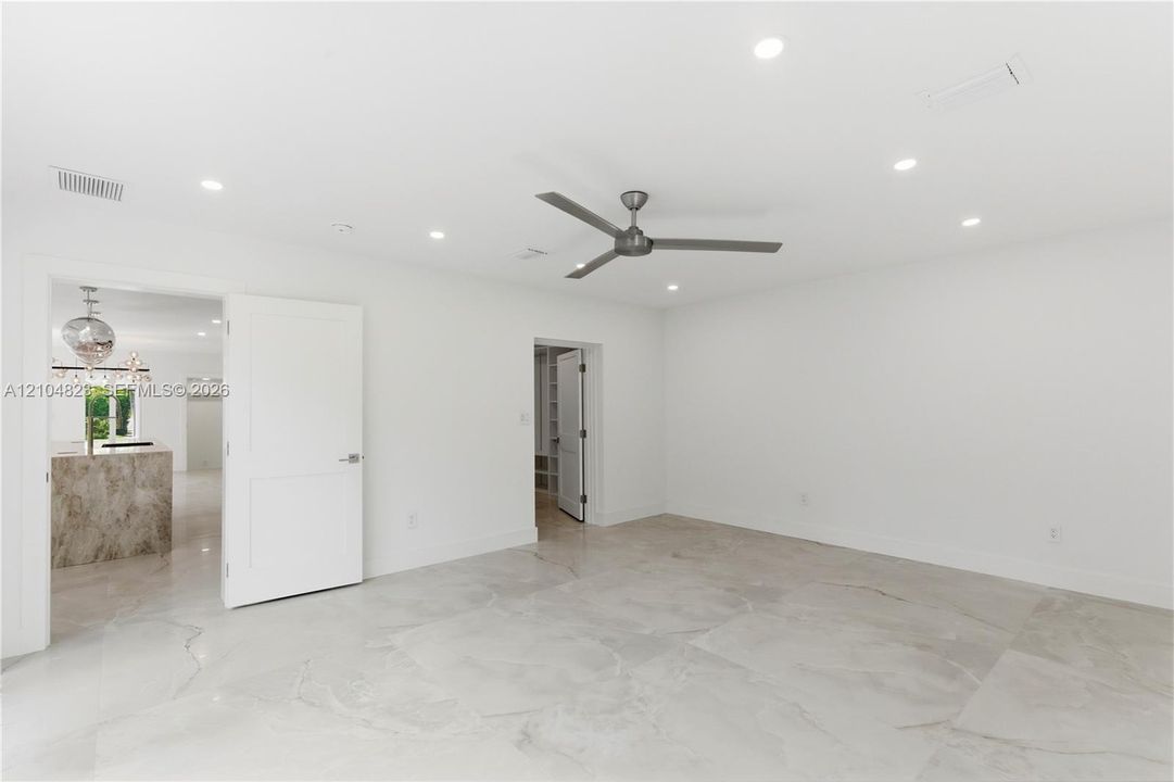 Neutral-toned tile flooring, recessed ceiling lighting, and a modern ceiling fan