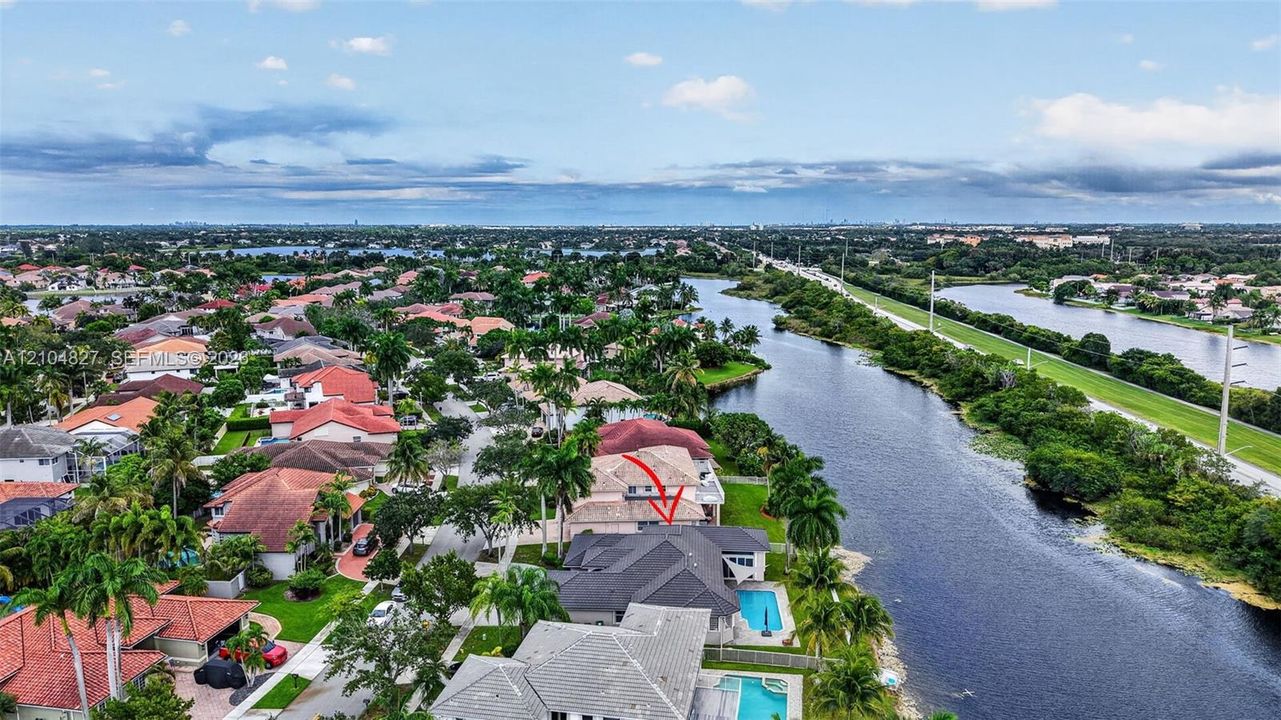 Waterfront residence featuring a private swimming pool, concrete tile roof, and expansive rear patio area