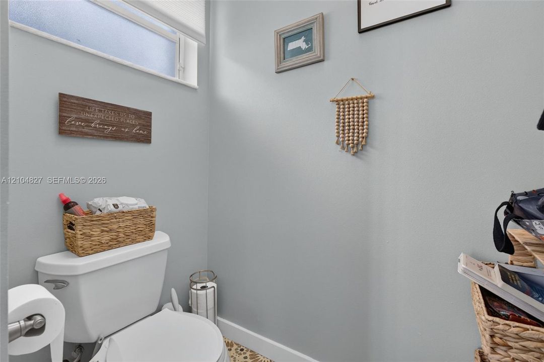 White vitreous china toilet, horizontal clerestory window, and patterned tile flooring