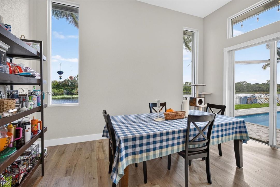 Wood-finish flooring, high ceilings, tall vertical windows, transom window, and sliding glass doors