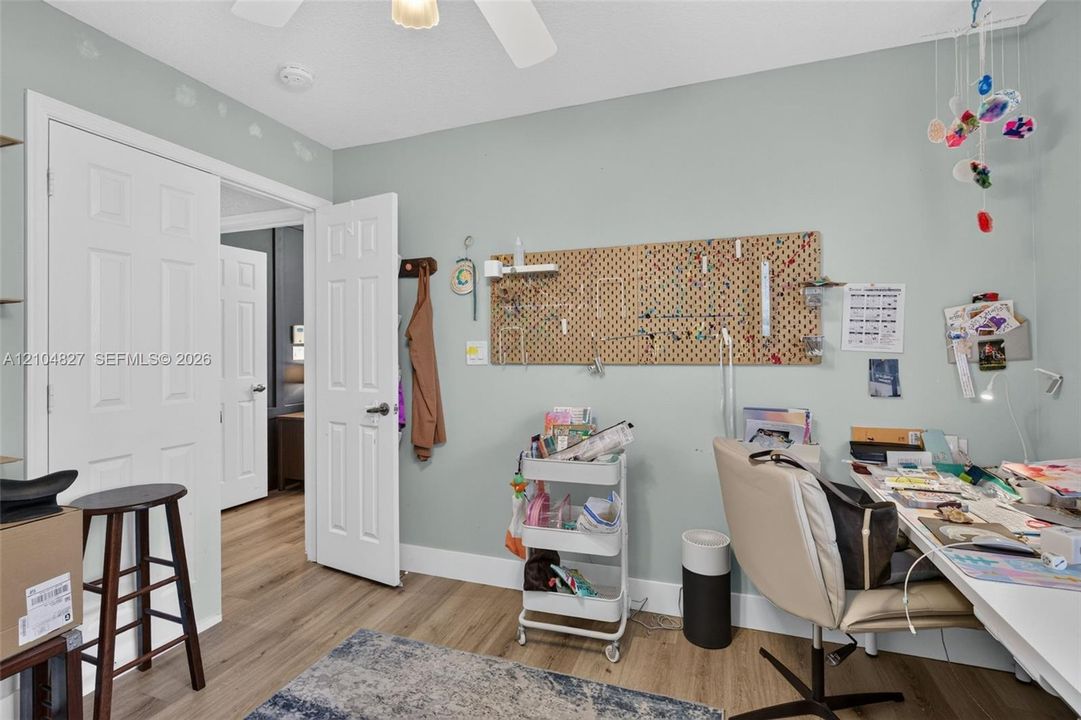 Wood-finish flooring, six-panel interior doors, and a ceiling-mounted light fixture