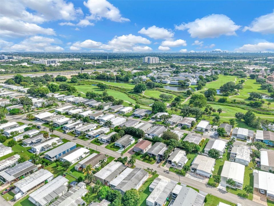 Aerial perspective featuring an established residential community with mature landscaping, green spaces, and integrated water features