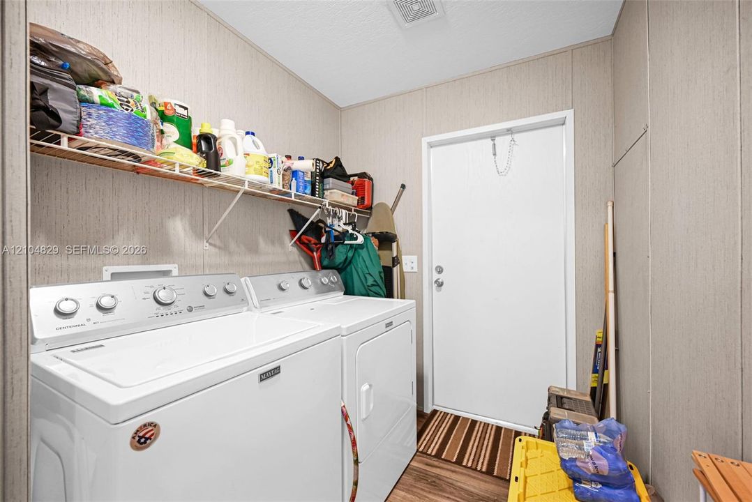 Utility area featuring built-in wire shelving and wood-finish flooring
