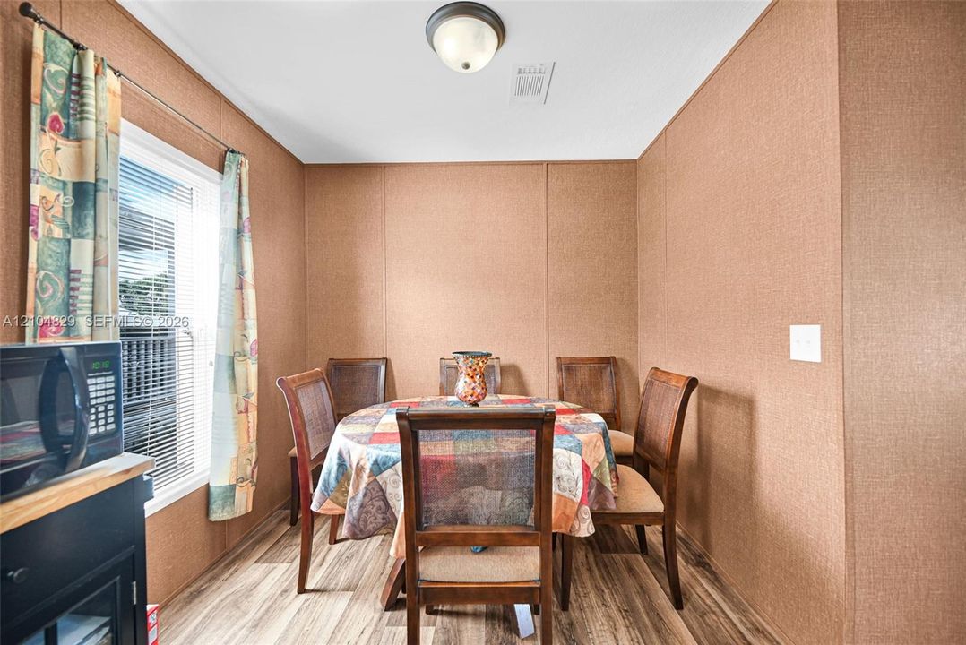 Textured wall panels, wood-finish flooring, and a flush-mount ceiling light fixture