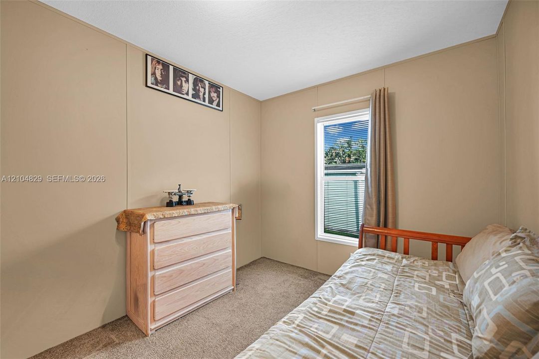 Neutral wall finish, carpeted flooring, and a single-pane window with a white frame