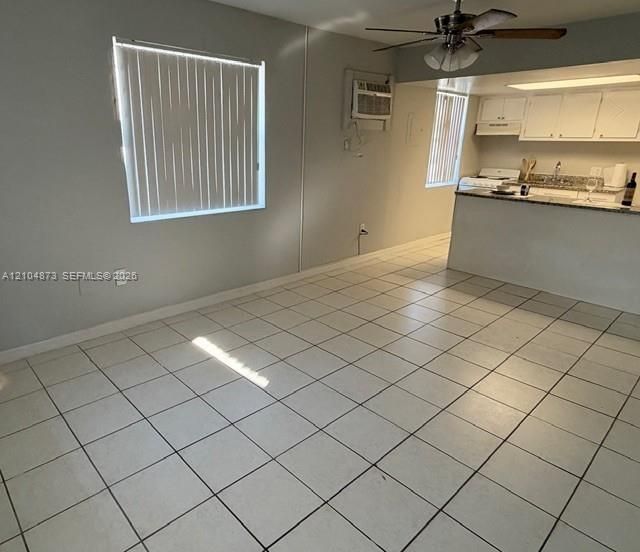 Ceramic tile flooring, kitchen with stone-finish countertops, ceiling fan, and window blinds