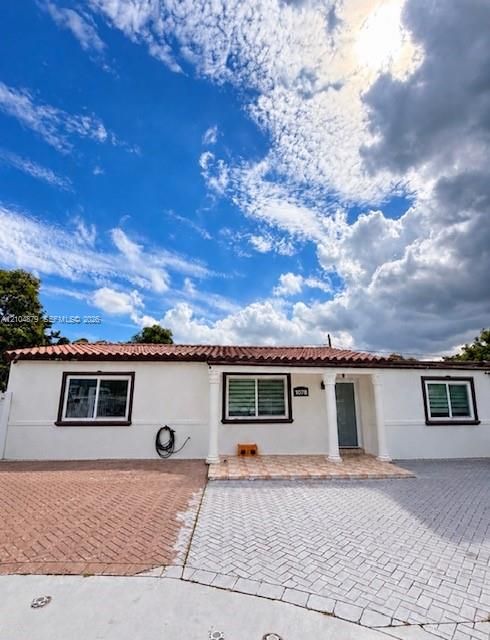 White stucco exterior with a terra cotta tile roof
