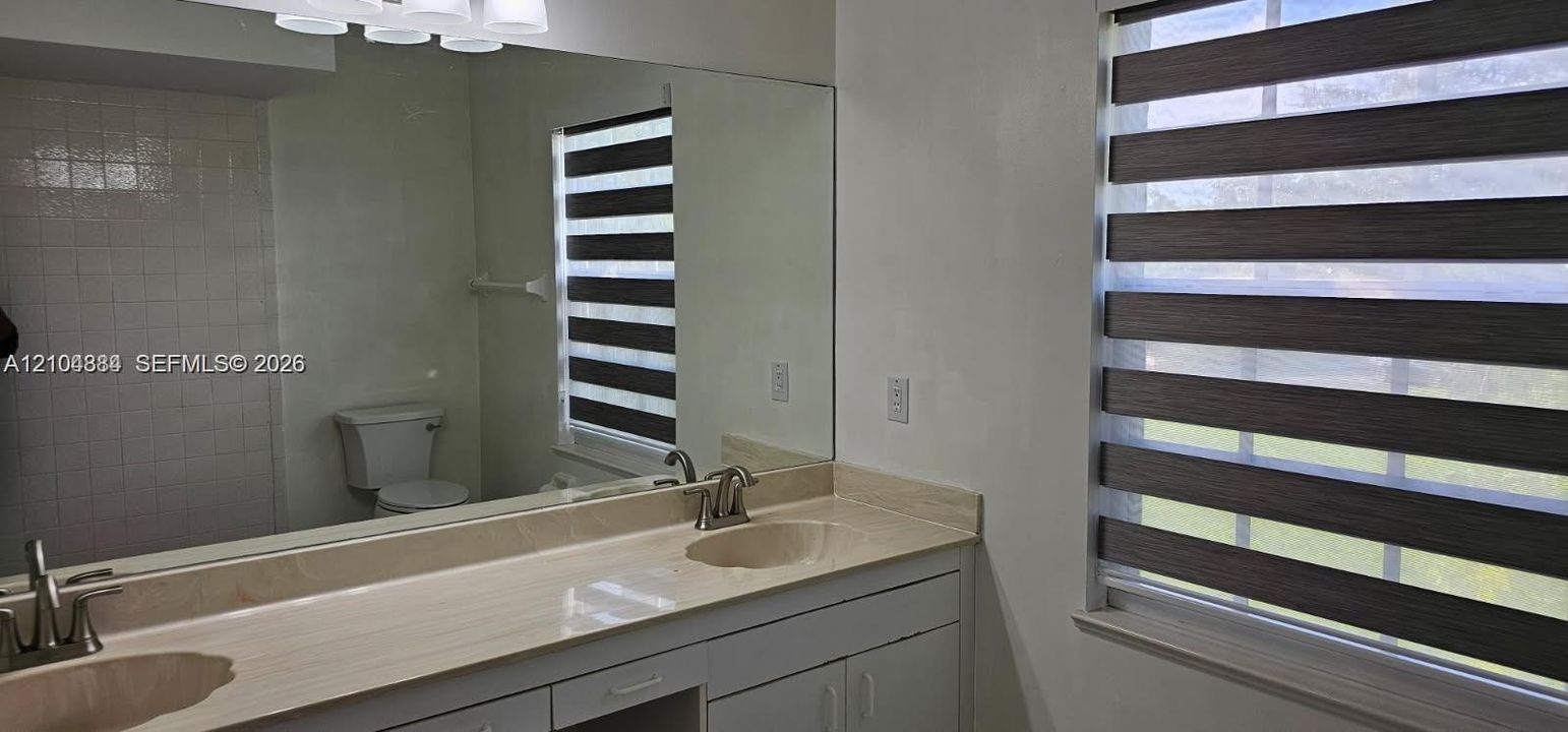 Dual vanity with integrated sinks, stone-finish countertop, and brushed nickel faucets