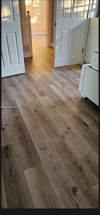 Wood-finish flooring throughout, complemented by white paneled doors