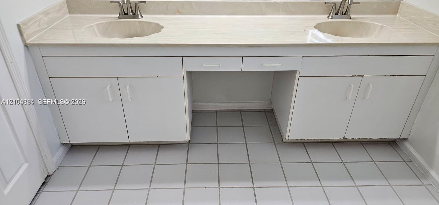 Dual vanity with integrated sinks, brushed nickel faucets, and a light-toned countertop