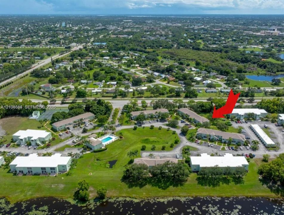 Aerial perspective highlighting a community with a central swimming pool and surrounding green spaces