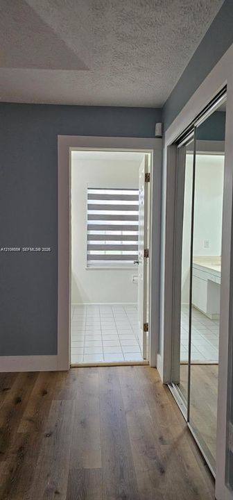 Wood-finish flooring, sliding mirrored closet doors, and recessed lighting