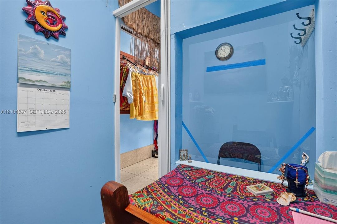 Interior room featuring a wall-mounted metal coat hook and a sliding closet door with tile flooring