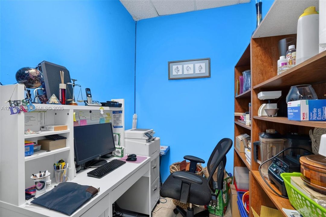 Built-in white workstation with integrated shelving and multi-drawer storage, complemented by full-height wood-finish shelving unit