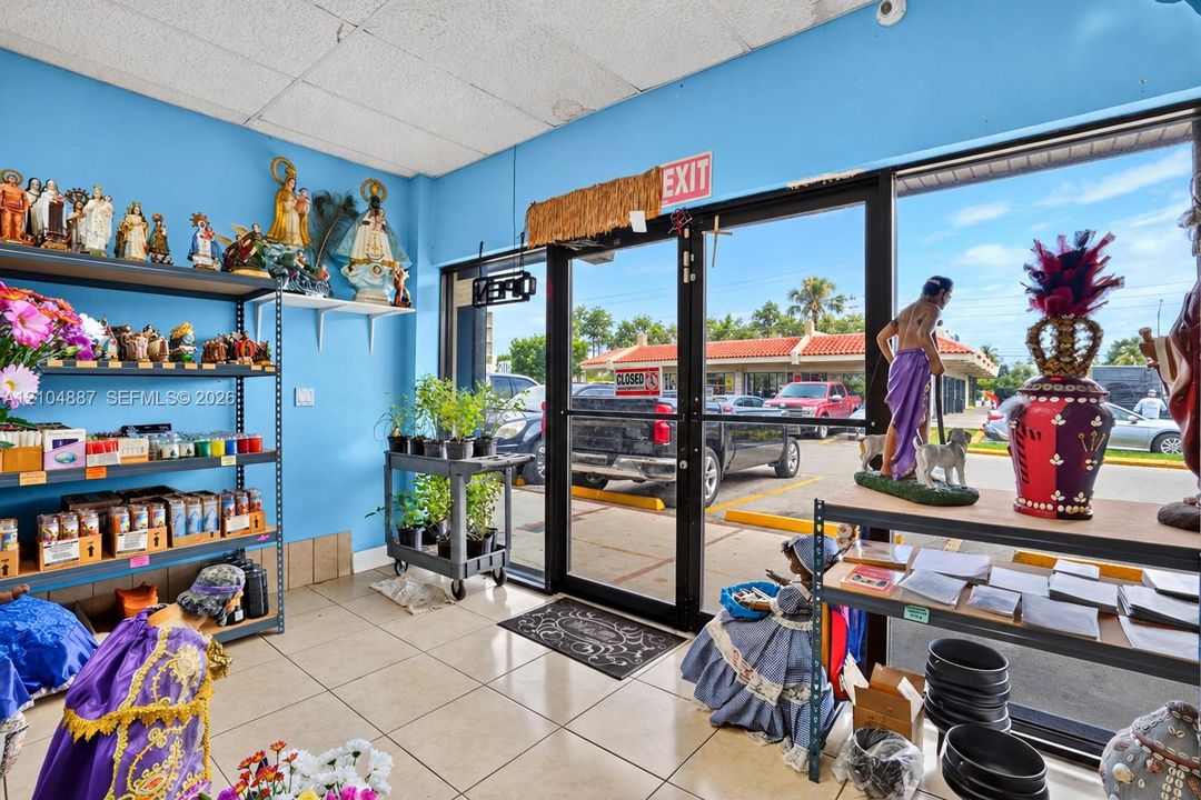 Commercial storefront interior featuring large-format ceramic floor tiles, expansive glass-paned double entry doors, and high-visibility window frontage