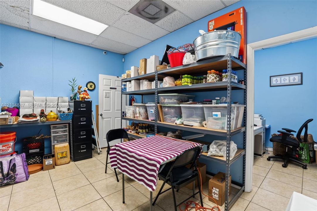 Room featuring tile flooring, drop ceiling with recessed lighting, and a solid-core interior door