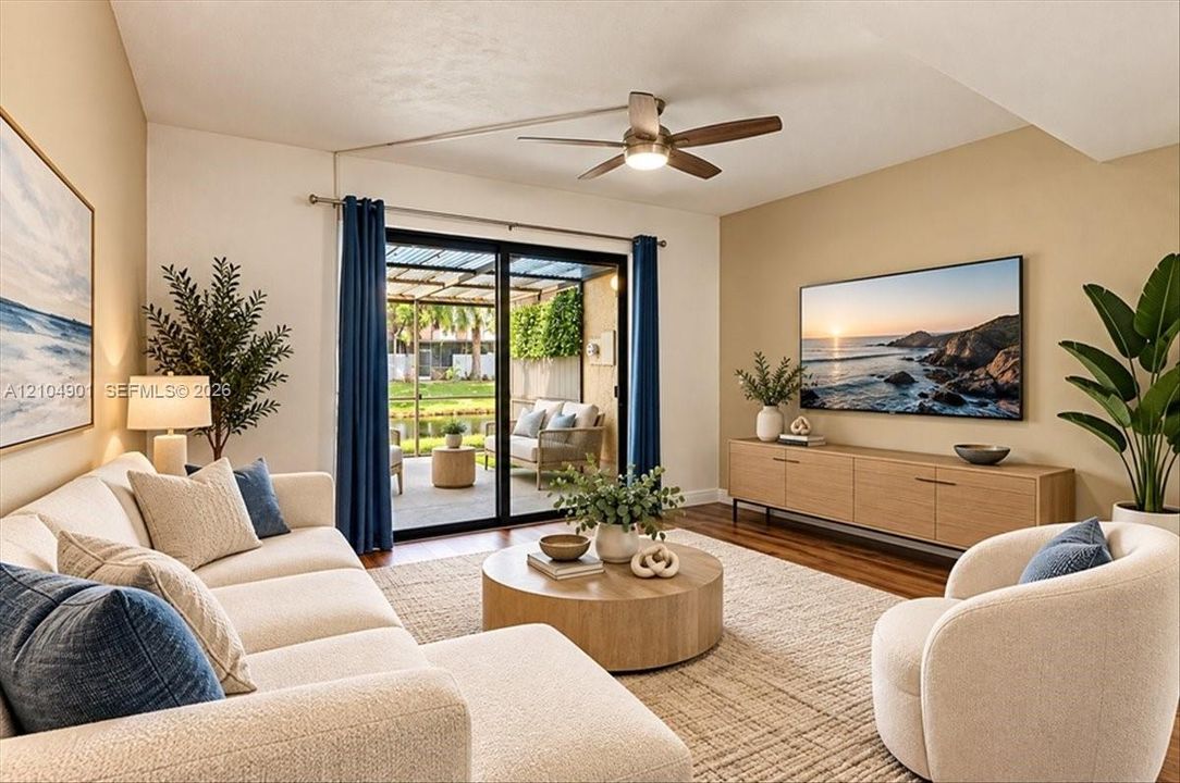 Vaulted ceilings with a central ceiling fan, wood-finish flooring, and sliding glass doors opening to a covered patio