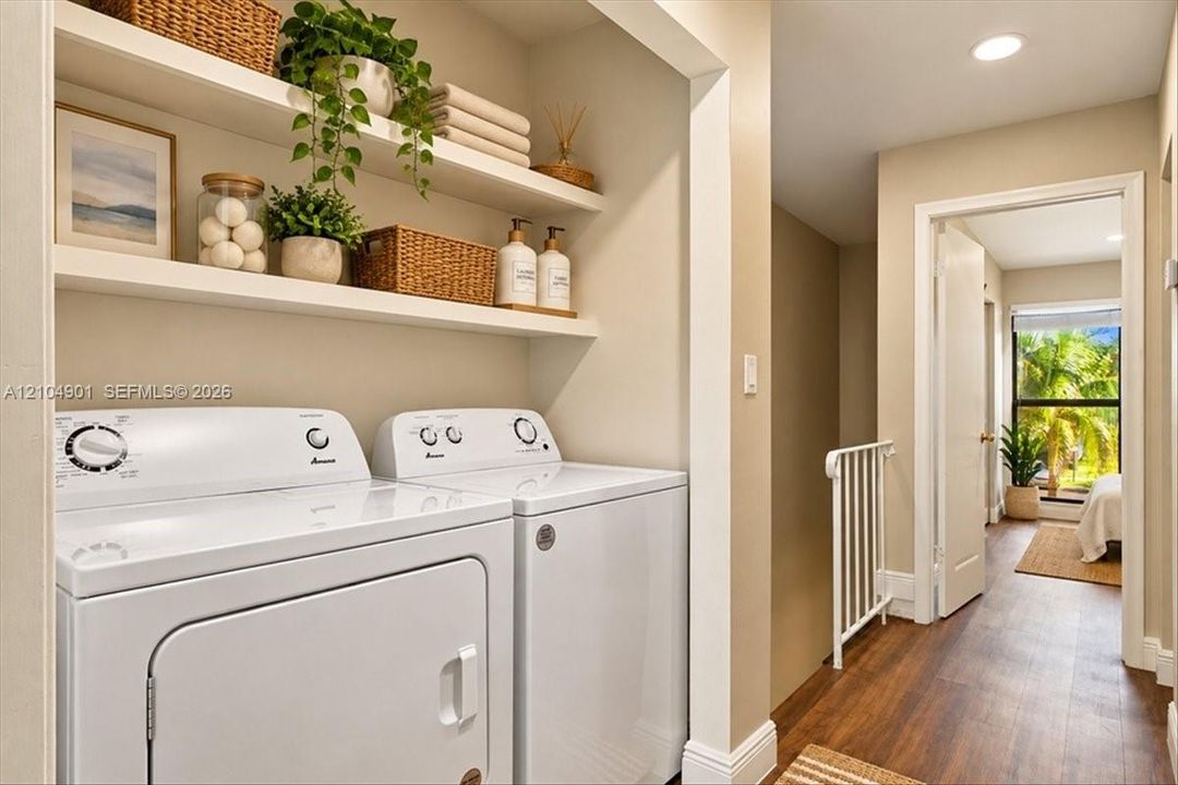Laundry area featuring built-in floating shelving, recessed lighting, and wood-finish flooring