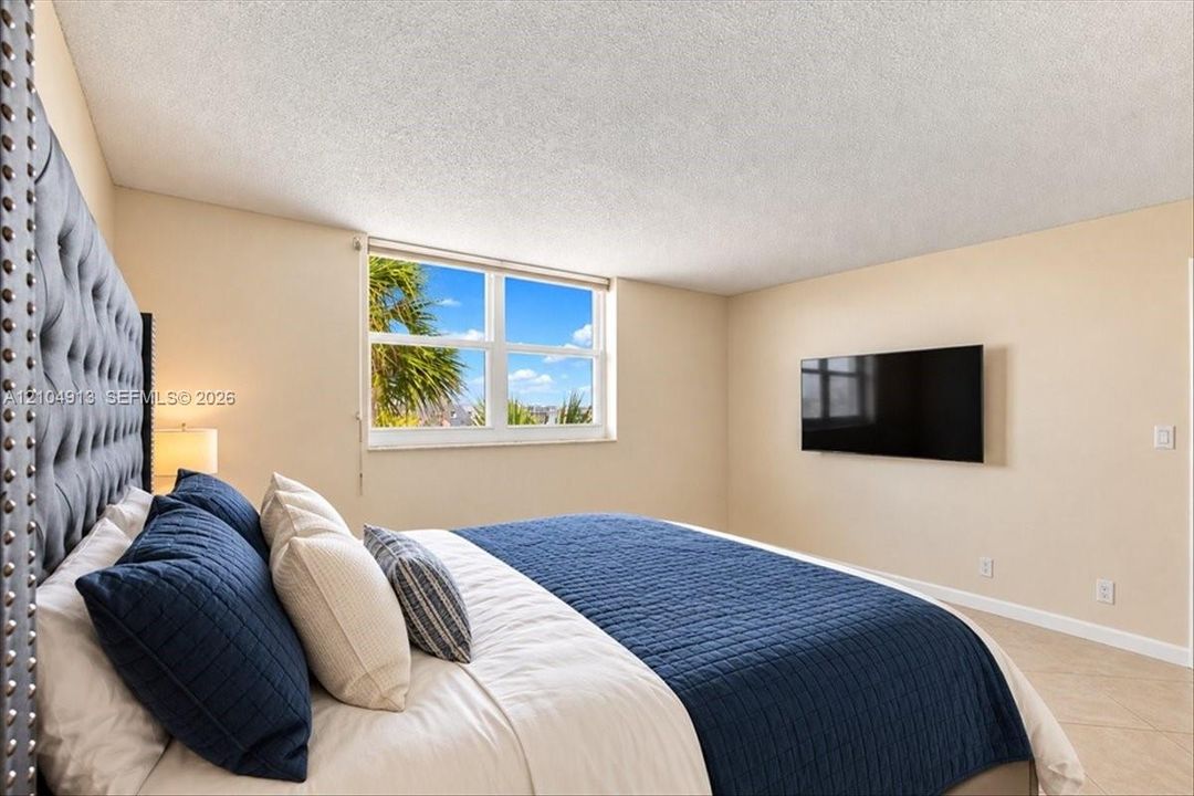 Room featuring neutral wall paint, large picture window, and tile flooring