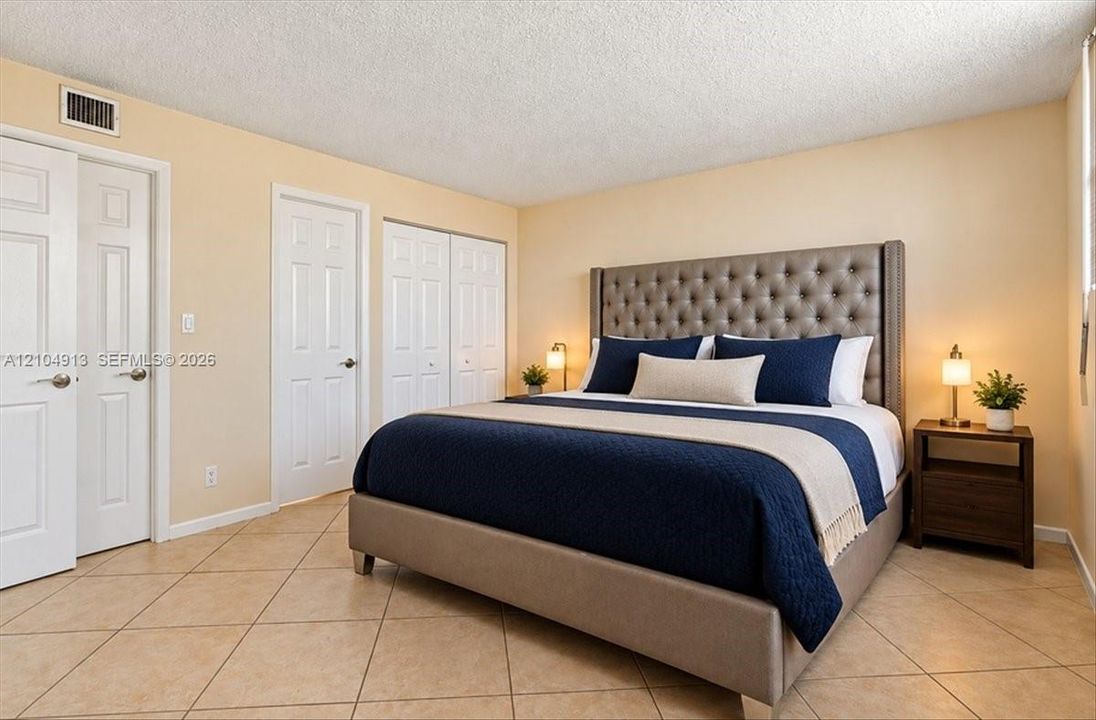 Neutral-toned interior featuring ceramic tile flooring, multi-panel doors, and double-door reach-in closet cabinetry