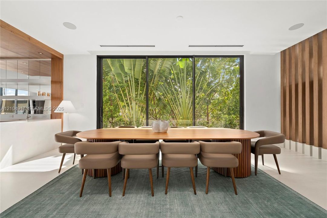 Floor-to-ceiling glass doors, wood-slat accent wall, recessed lighting, and a built-in counter