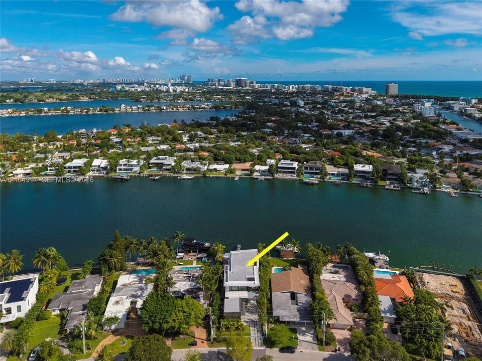 Waterfront property featuring a private boat dock, swimming pool, flat roof architectural design, and direct waterway access