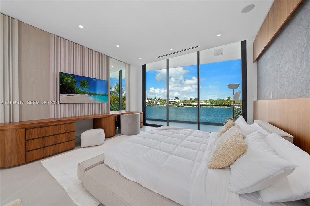 Full-height windows, custom built-in cabinetry, wood-finish wall accents, integrated lighting, and a neutral color palette